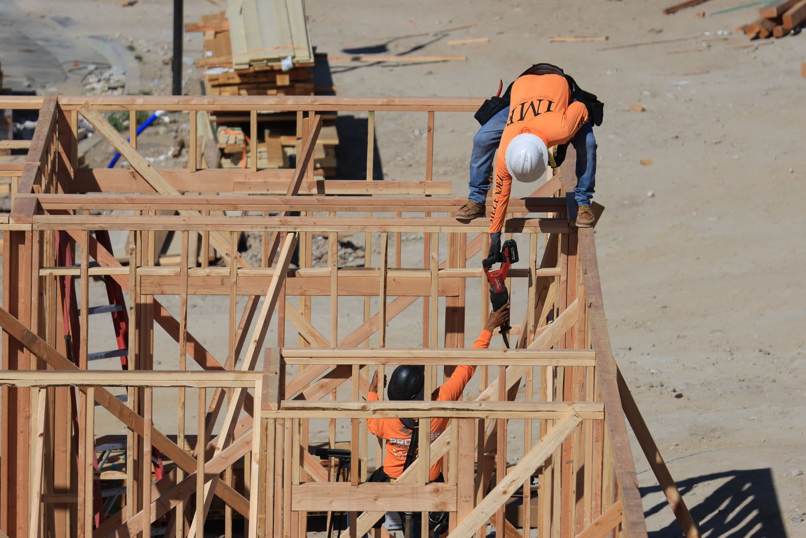 Framing crew raising second-story walls on a job site